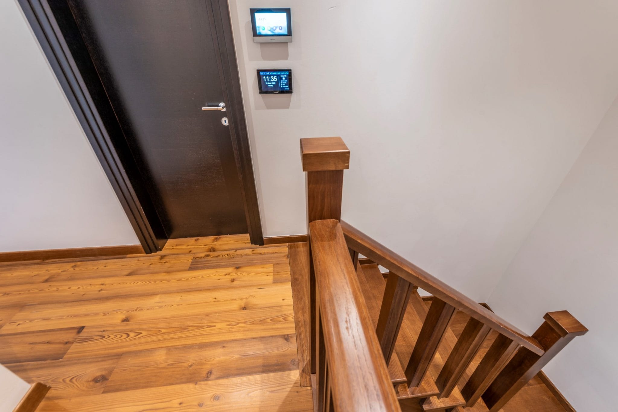 Holztreppe und Smart-Home-System im Penthouse in Bečići, Montenegro. Modernes Interieur mit Holzverkleidung.