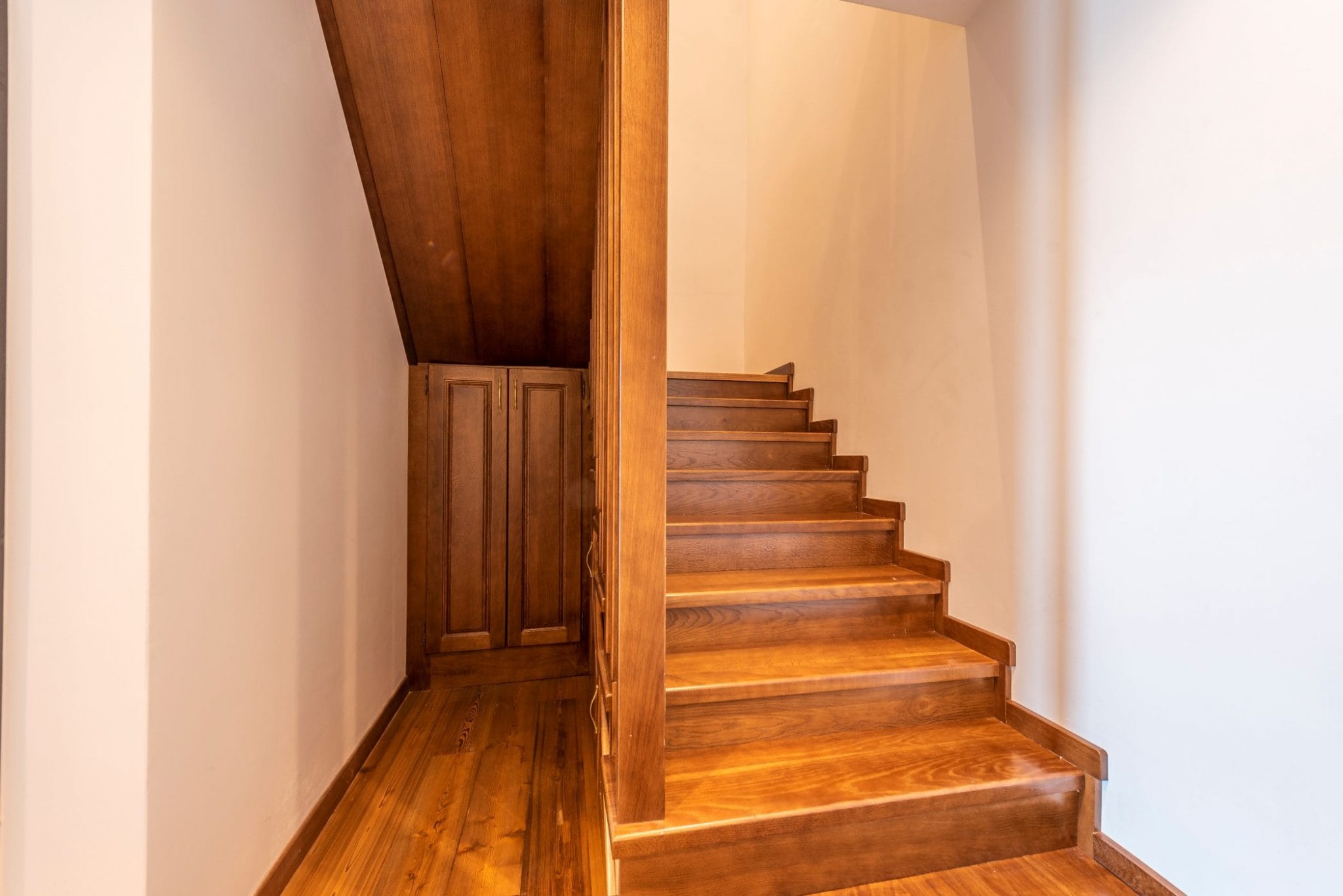 Holztreppe mit eingebautem Schrank im Interieur eines Penthouses in Bečići, Montenegro. Hochwertige Holzverkleidung.