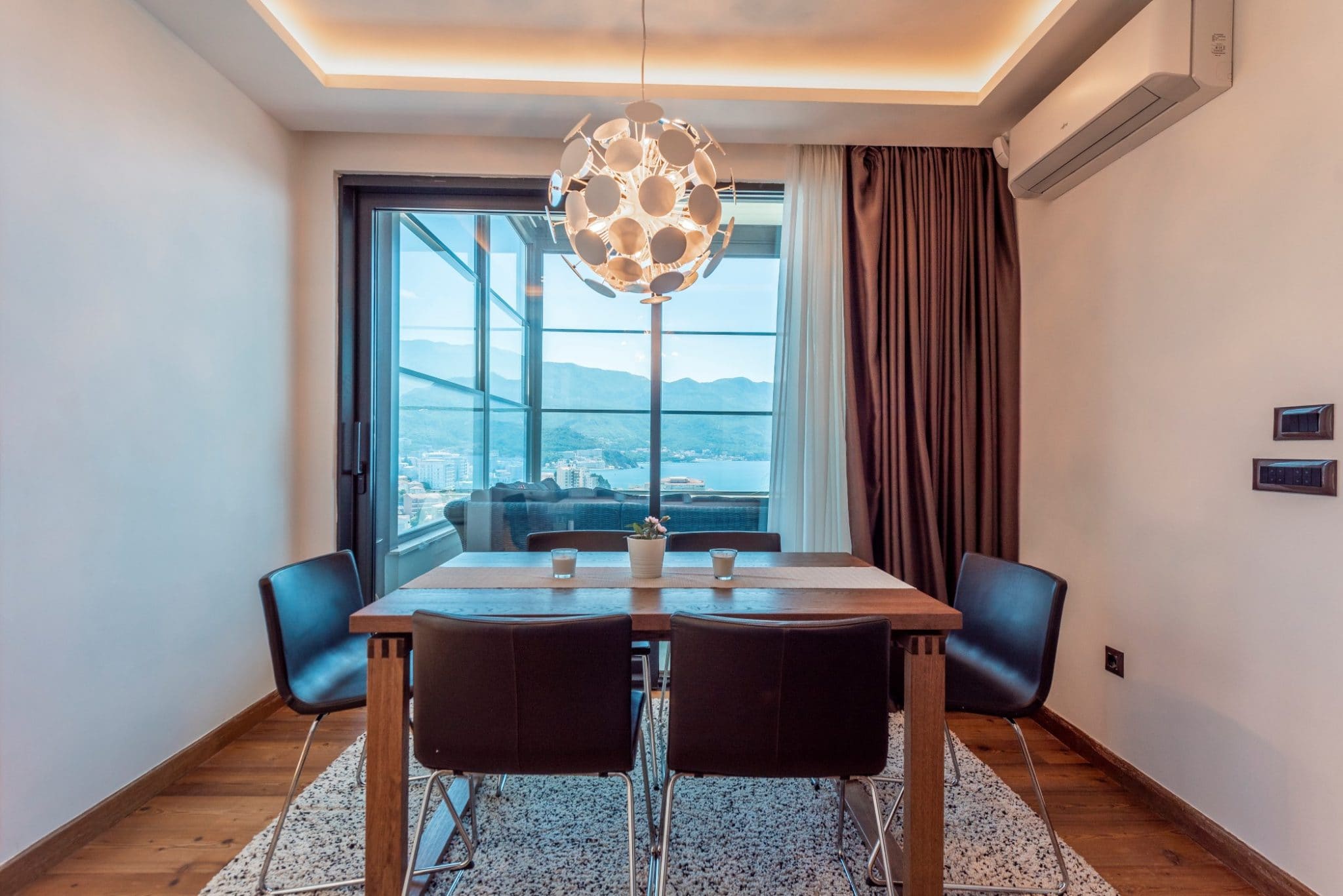 Moderner Essbereich im Penthouse in Bečići, Montenegro: Holztisch, Panoramablick auf Meer und Berge.