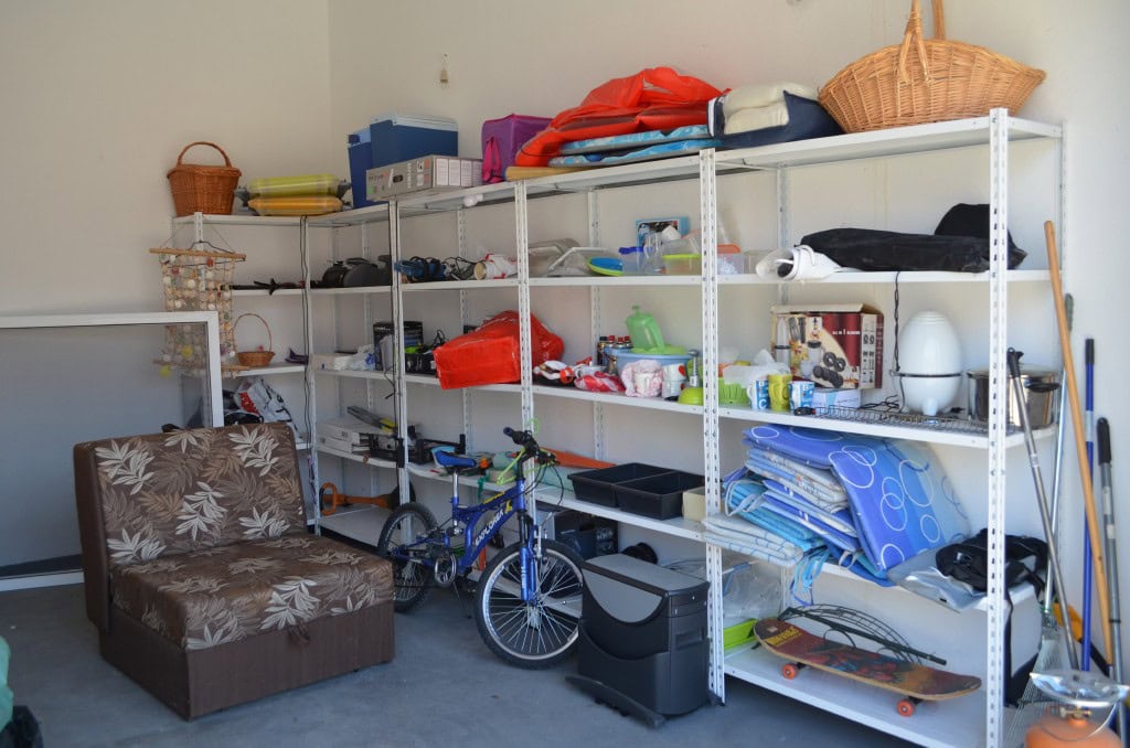 Bar, Karadağ’daki apartman dairesinde depo odası: eşyalar, bisiklet ve saklama için bir koltuk bulunan metal raflar.