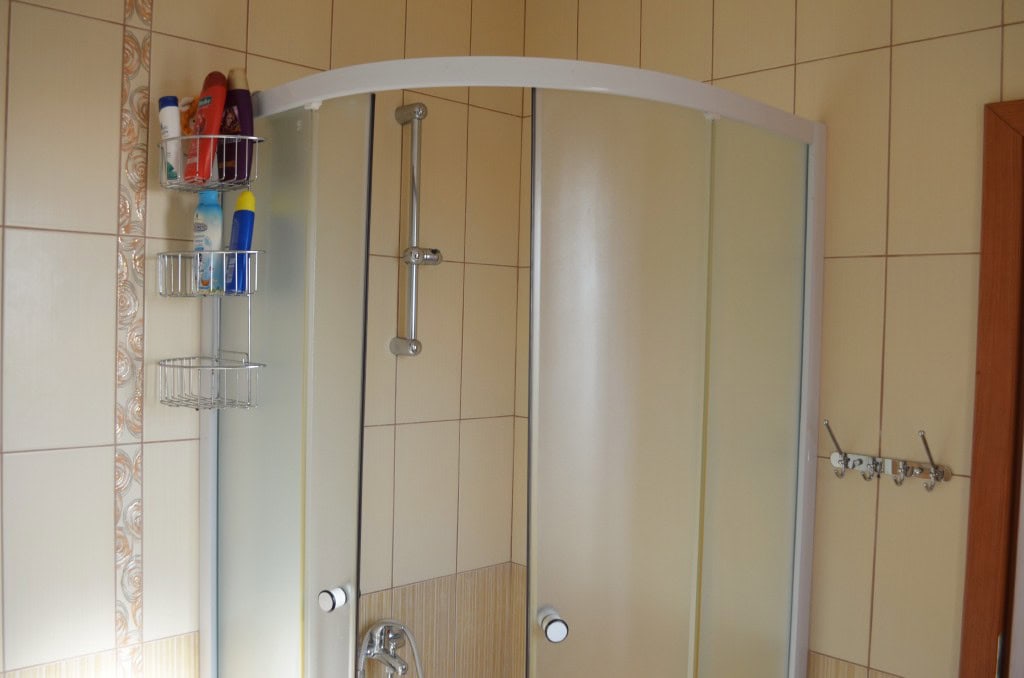 Bar, Karadağ’daki apartman dairesinde duş kabinli banyo: bej fayans ve sıhhi tesisat.