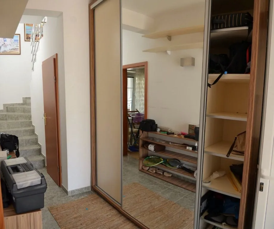 Eingangsbereich mit Spiegelschiebetürenschrank und Treppe in einer zweistöckigen Wohnung, Stadt Bar, Montenegro.