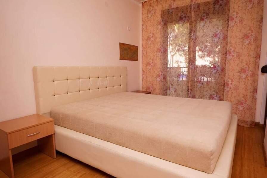 Gemütliches Schlafzimmer mit Doppelbett und Zugang zum Balkon in einer Wohnung in Budva, Montenegro.
