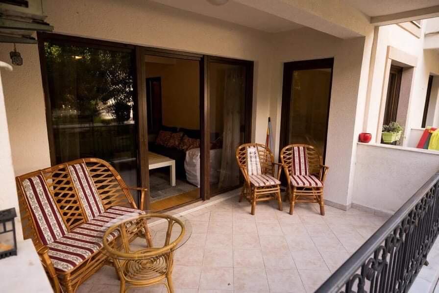 Gemütliche Terrasse mit Rattanmöbeln und Panoramafenstern in einer Wohnung in Budva, Montenegro.