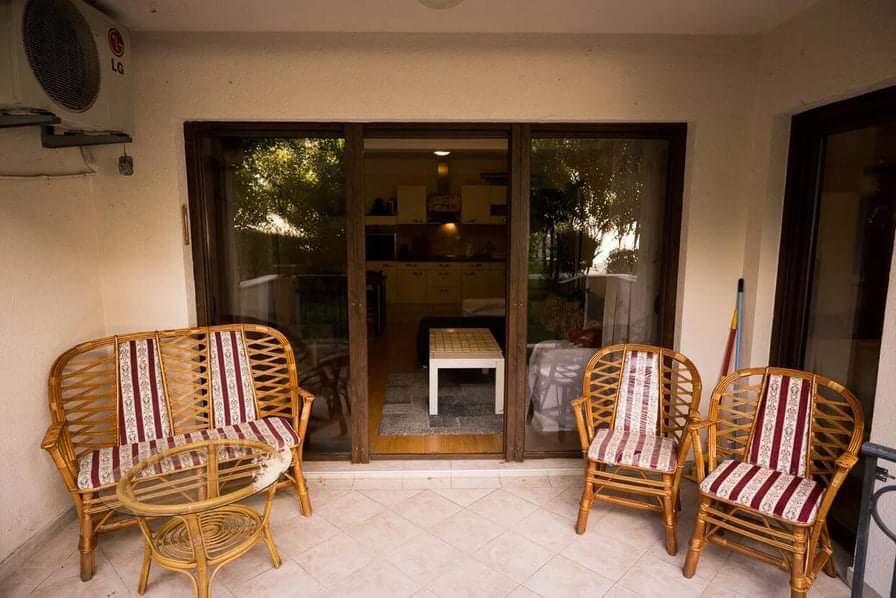 Gemütliche Terrasse mit Rattanmöbeln in einer Wohnung in Budva, Montenegro, mit Zugang zum Wohnzimmer durch Panoramatüren.