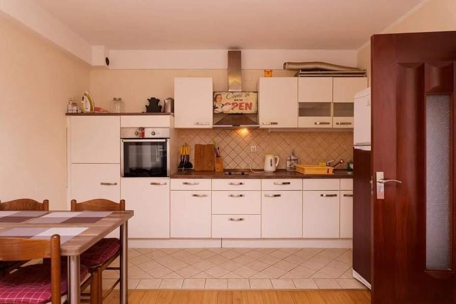 Helle Küche mit Einbaugeräten und Essbereich in einer Wohnung in Budva, Montenegro.