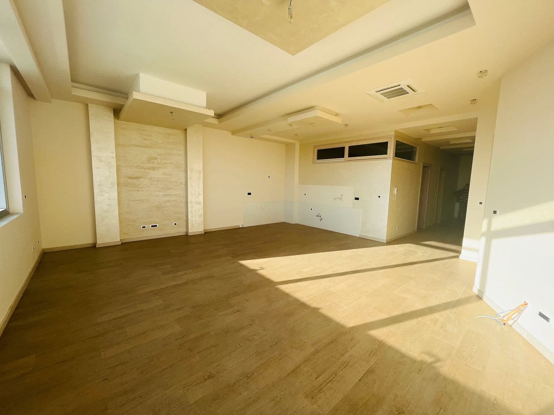 Geräumiges Wohnzimmer mit hochwertiger Endausstattung und mehrstufiger Decke in einer neuen Wohnung in Budva, Montenegro.