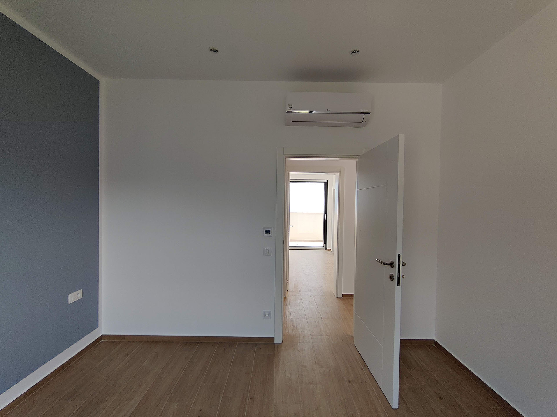 Bright bedroom in an apartment, Becici, Montenegro: modern finishes, laminate flooring, air conditioning, and access to the balcony.