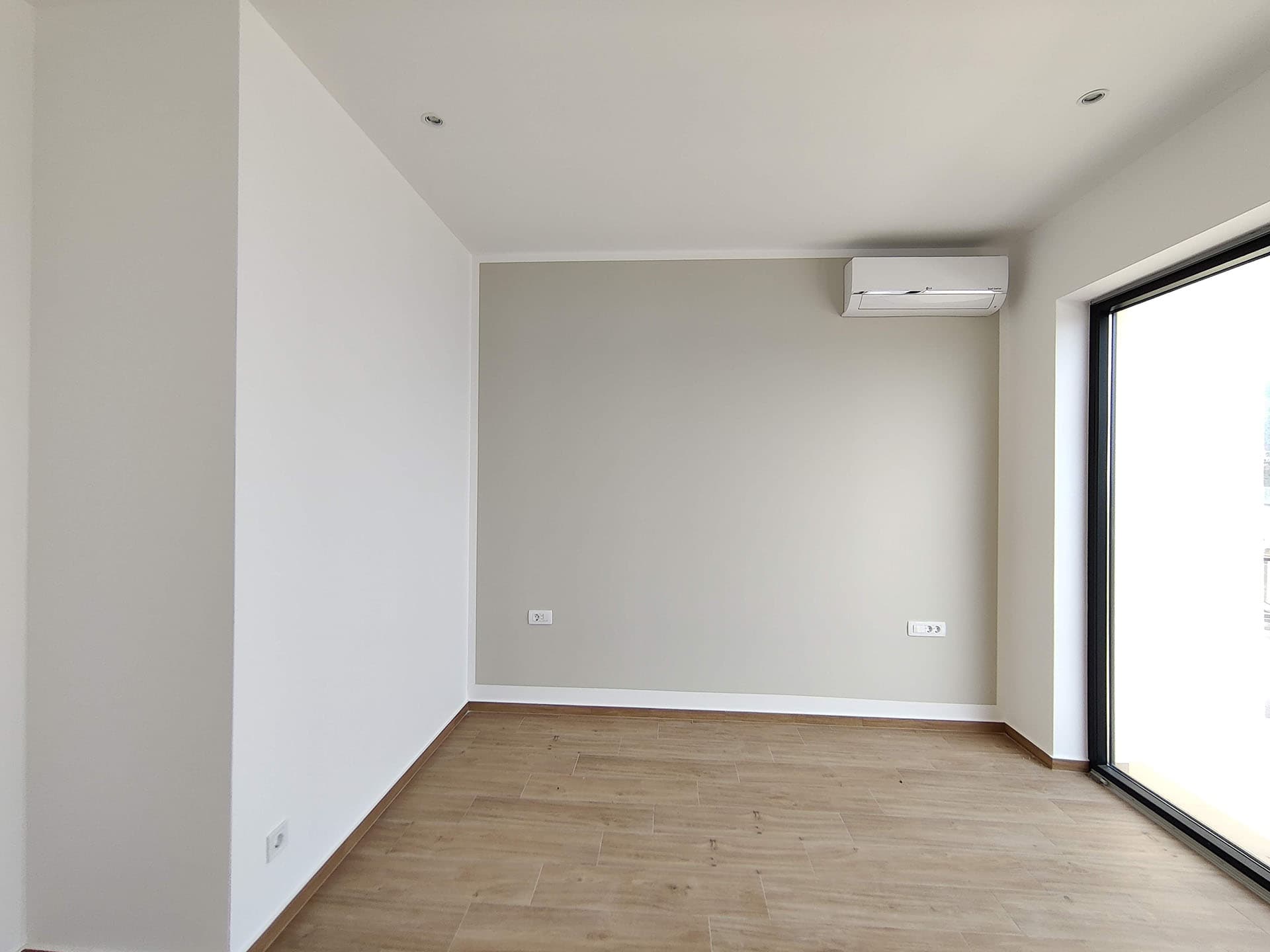 Bright living room with air conditioning and a panoramic window in a new apartment, Becici, Montenegro.