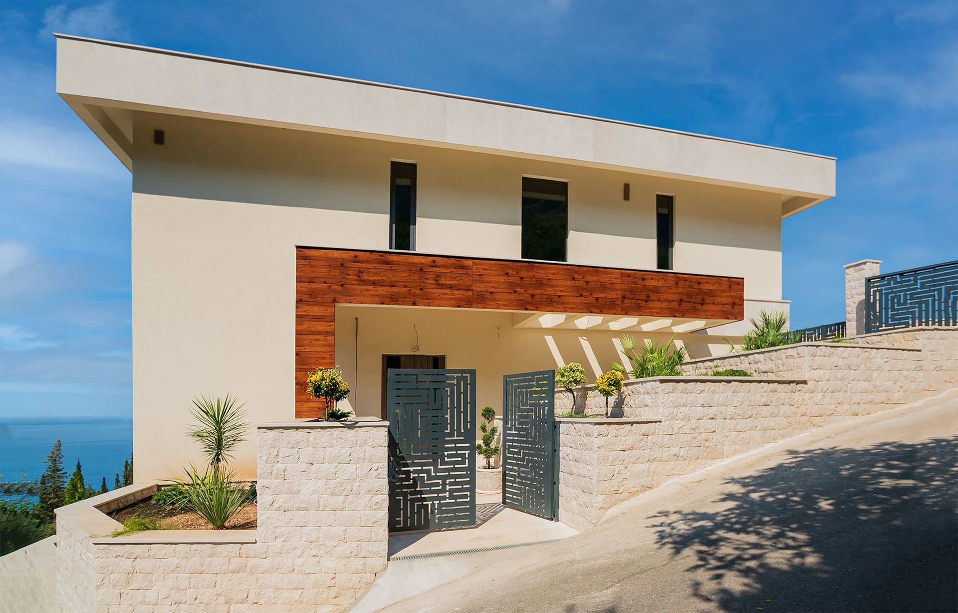 Karadağ, Drobni Pijesak’ta modern villa: ahşap kaplamalı cephe, taş çit ve deniz manzarası.