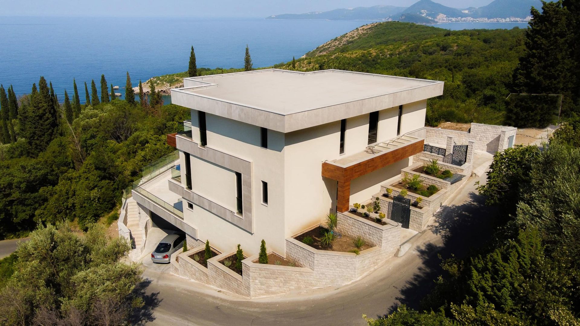 Karadağ, Drobni Pijesak’ta teraslı ve deniz manzaralı modern villa: taş kaplamalı dış cephe ve otopark.