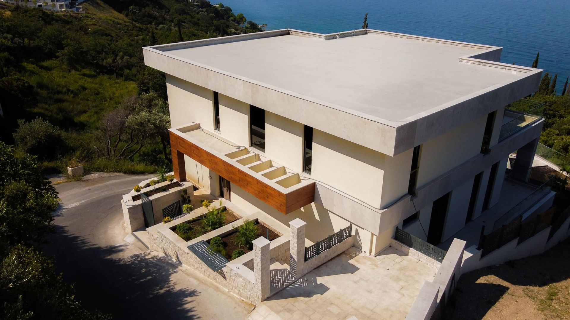 Karadağ, Drobni Pijesak’ta deniz manzaralı düz çatılı modern villa: ahşap kaplamalı cephe ve teras.