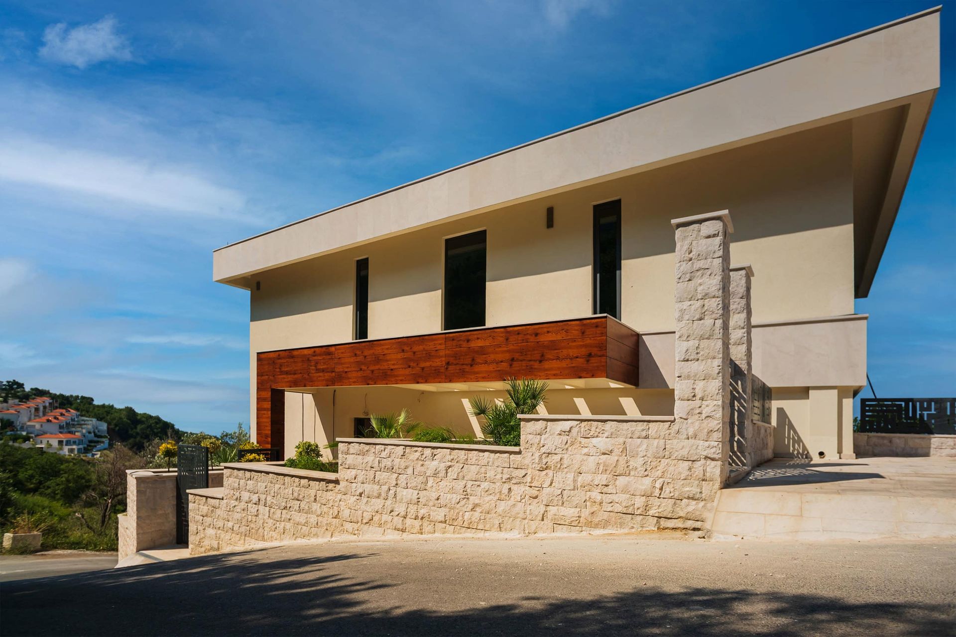 Karadağ, Drobni Pijesak’ta modern villa: taş ve ahşap cephe, panoramik pencereler ve peyzaj tasarımı.