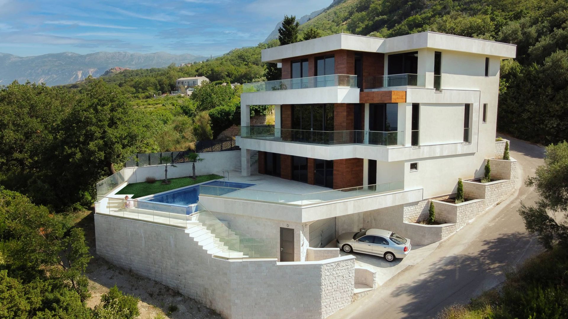 Karadağ, Drobni Pjesak’ta havuzlu ve teraslı modern üç katlı villa: evin ve dağların yukarıdan görünümü.