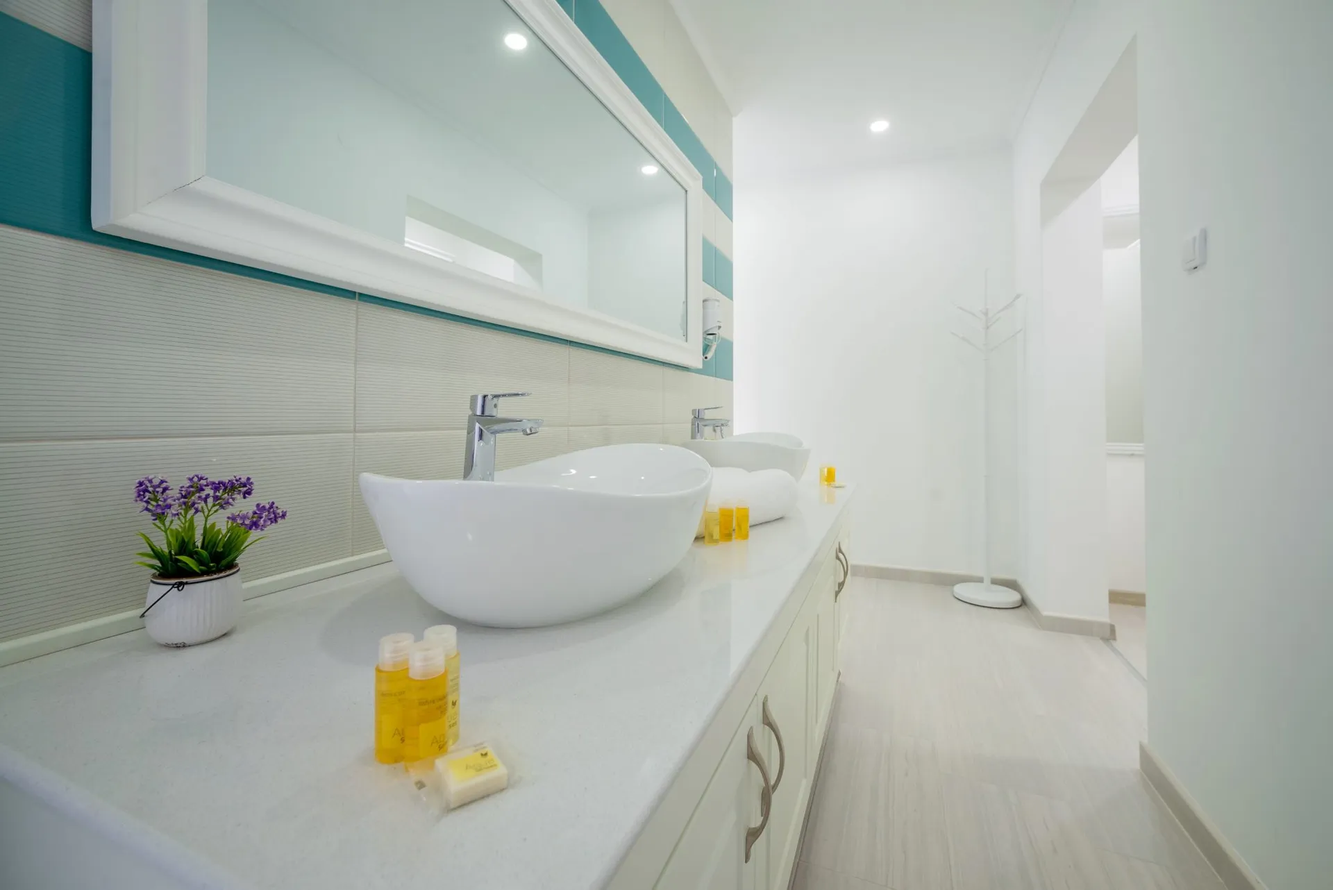 Helles, modernes Badezimmer mit zwei weißen Waschbecken und großem Spiegel.