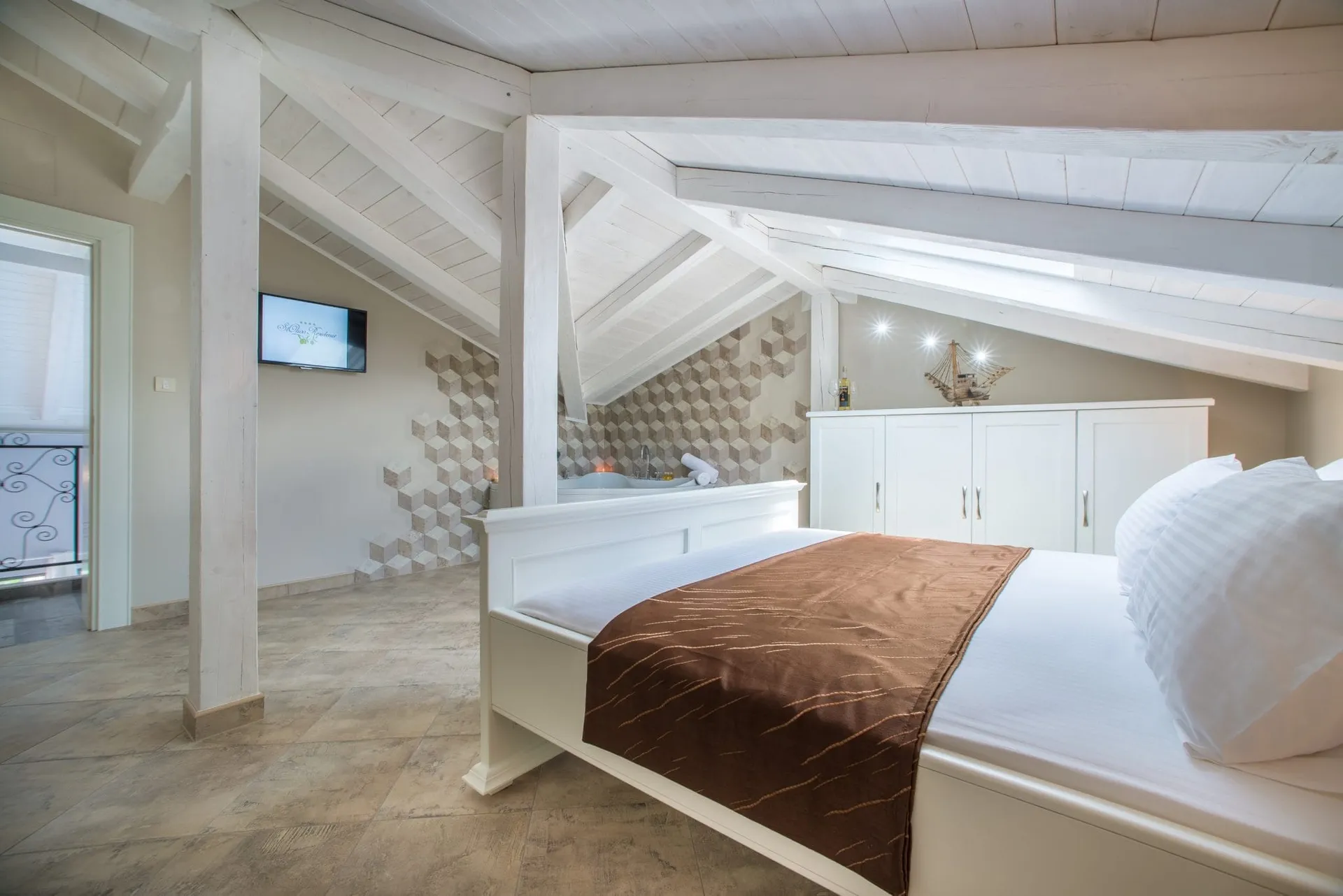 Dachschlafzimmer mit weißem Bett und Kleiderschrank