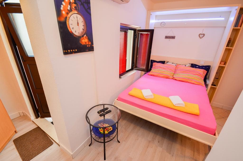 Gemütliches Schlafzimmer mit Doppelbett in einem Haus in Kotor, Montenegro: helles Interieur, moderne Möbel und Dekor.