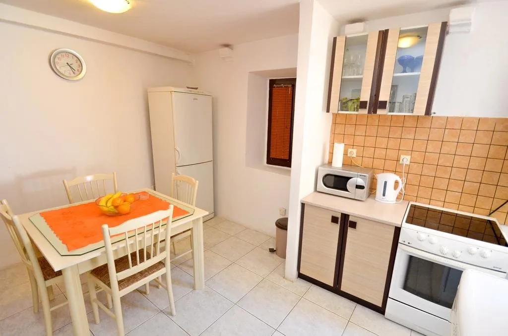 Bright kitchen-dining room in a house in Kotor, Montenegro: dining area, kitchen set, stove, and appliances.