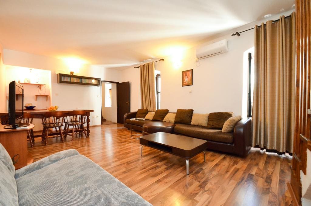 Geräumiges Wohnzimmer mit Ledersofa und Holzboden in einem Haus in Kotor, Montenegro.
