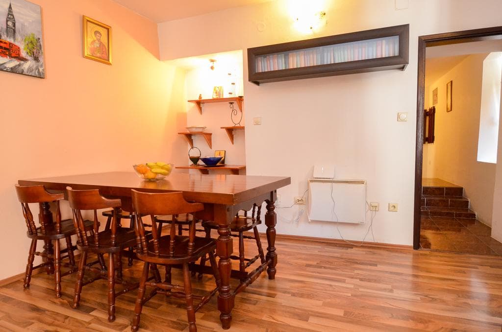 Wohnzimmer mit Holzesstisch und Stühlen in einem Haus in Kotor, Montenegro: Innenraum mit Regalen und Dekor.