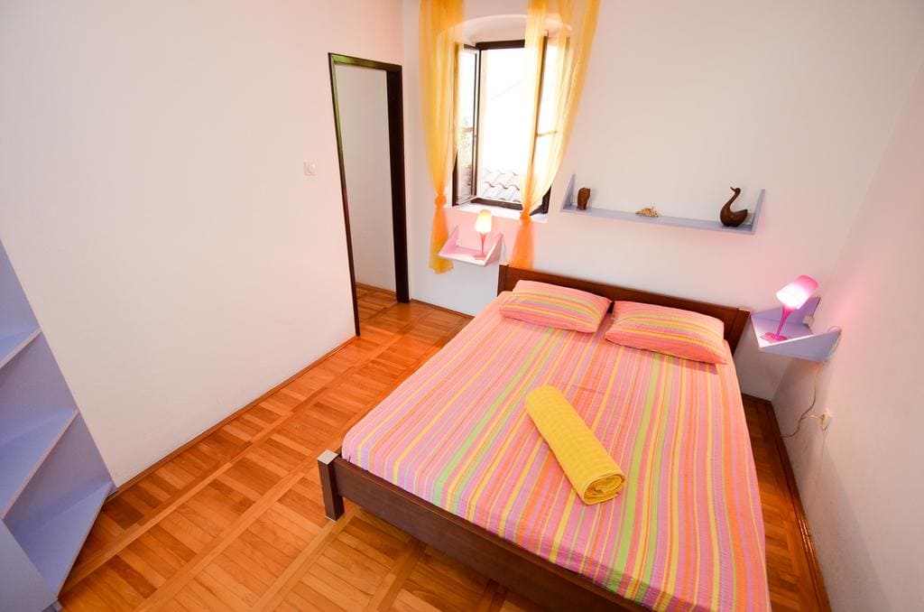 Gemütliches Schlafzimmer mit Doppelbett und Parkett in einem Haus zum Verkauf in Kotor, Montenegro.