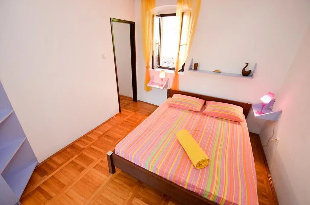 Cozy bedroom with a double bed and parquet flooring in a house for sale in Kotor, Montenegro.