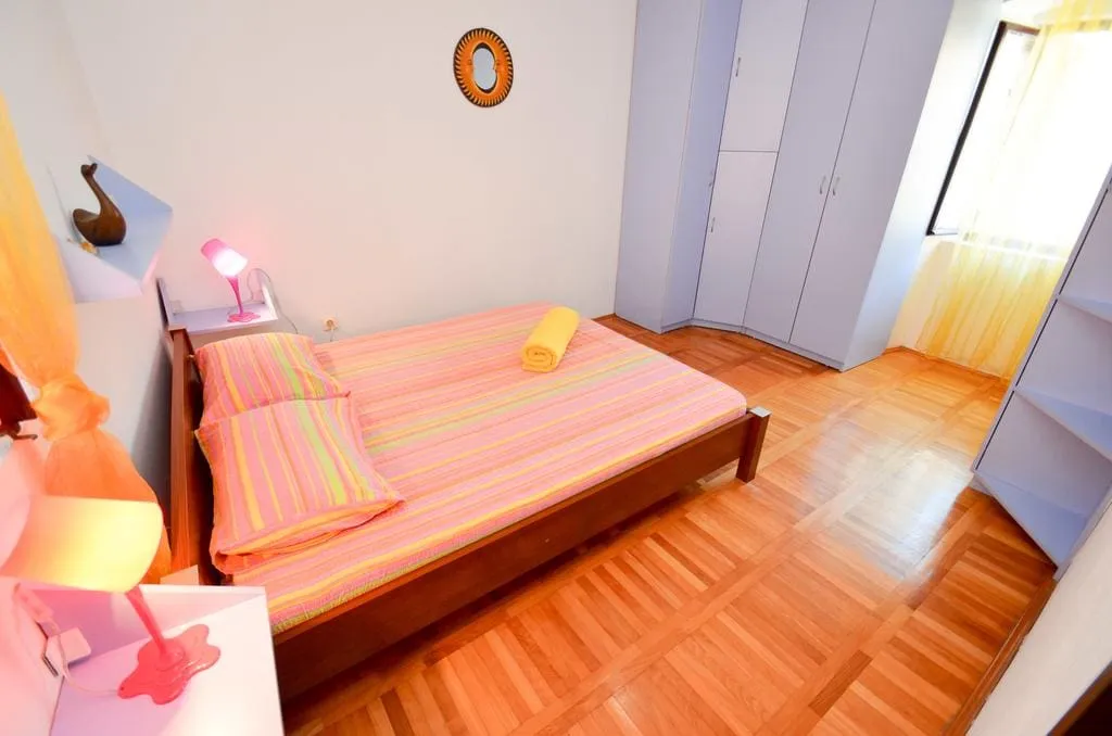 Cozy bedroom with a double bed and parquet flooring in a house for sale, Kotor, Montenegro.