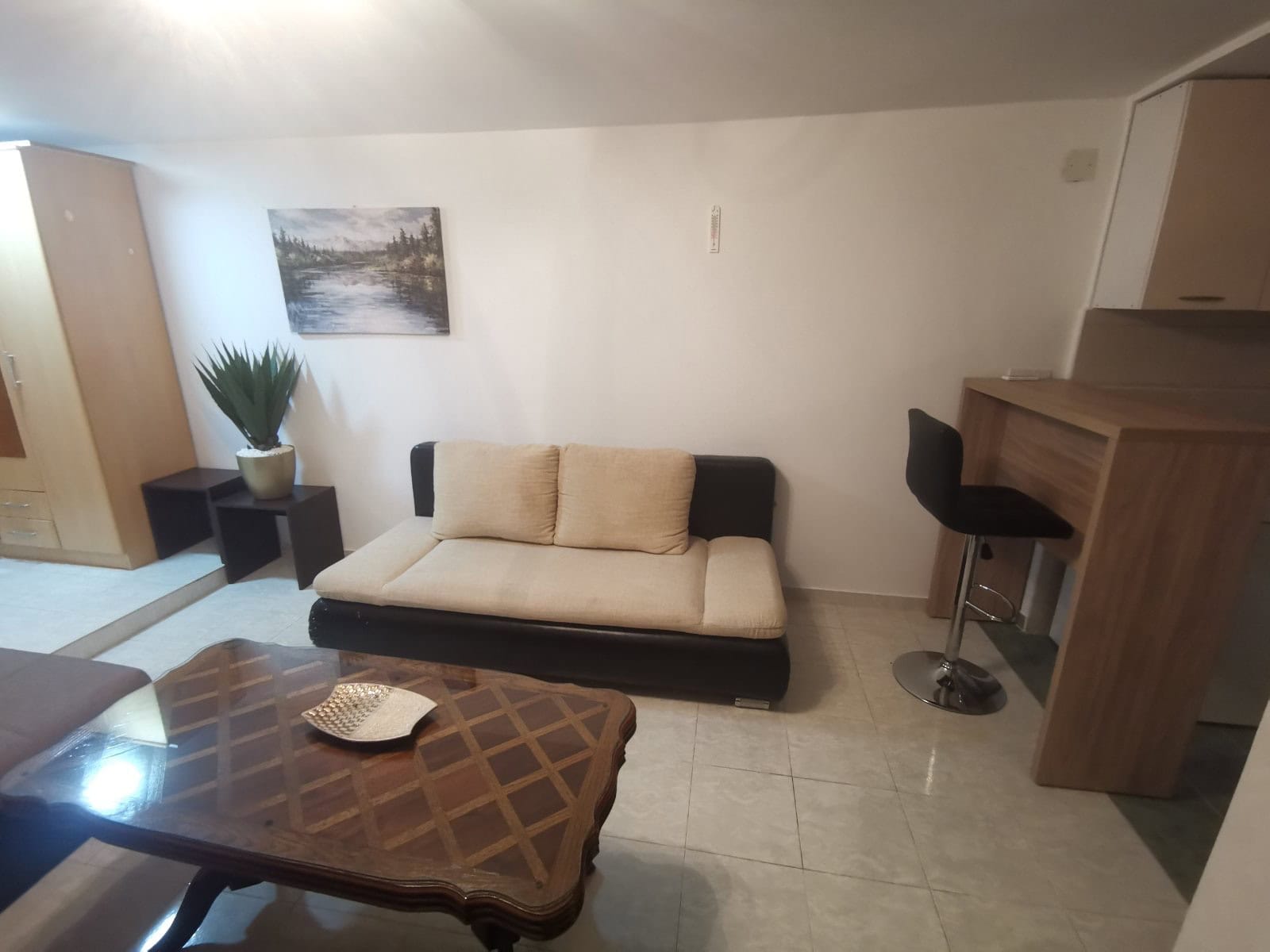 Wohnzimmer in einer Wohnung in Budva, Montenegro: Sofa, Bartheke, Couchtisch und helle Innenausstattung.