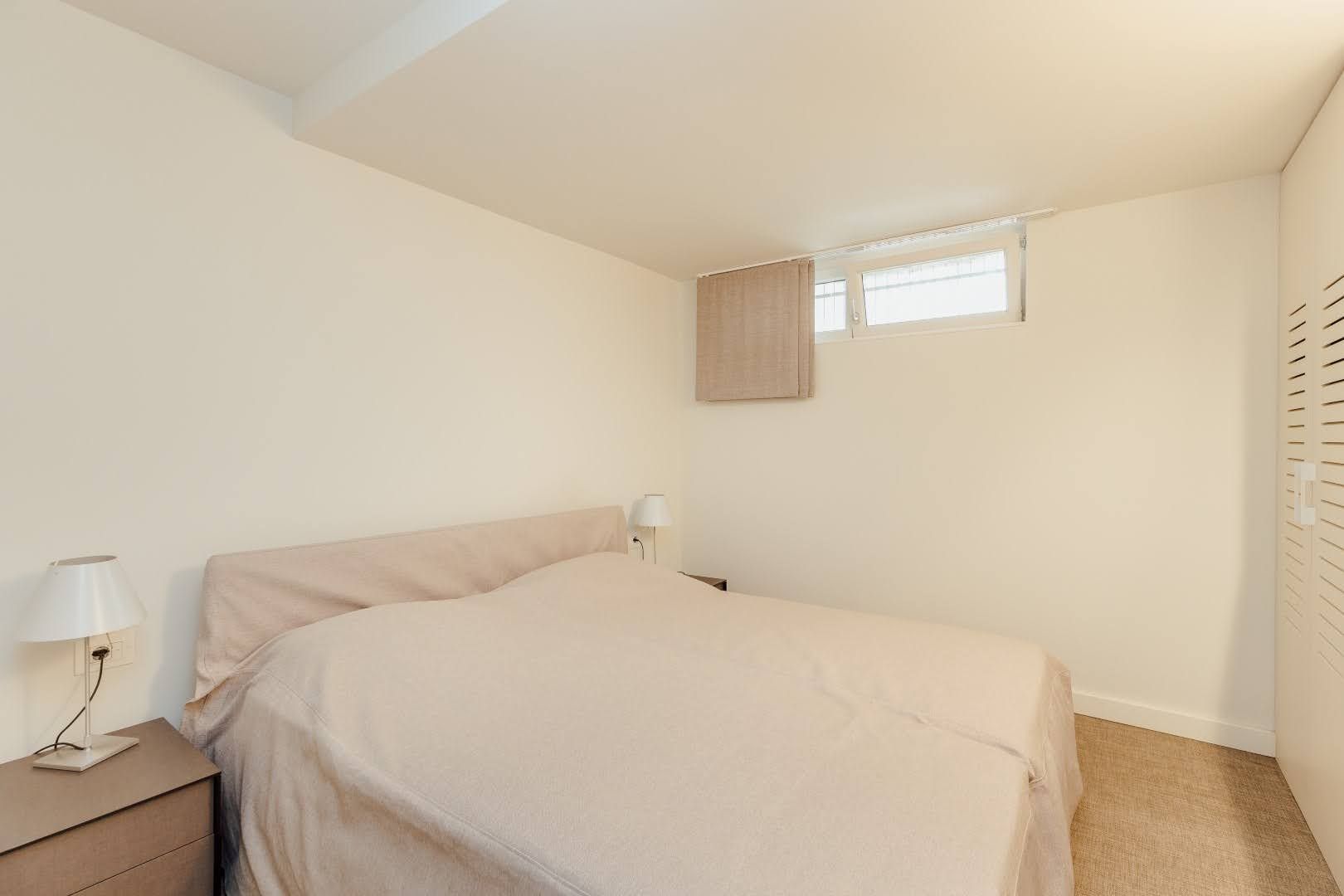 Bright bedroom with a double bed and built-in wardrobe in a villa in Pržno, Montenegro. Modern interior.