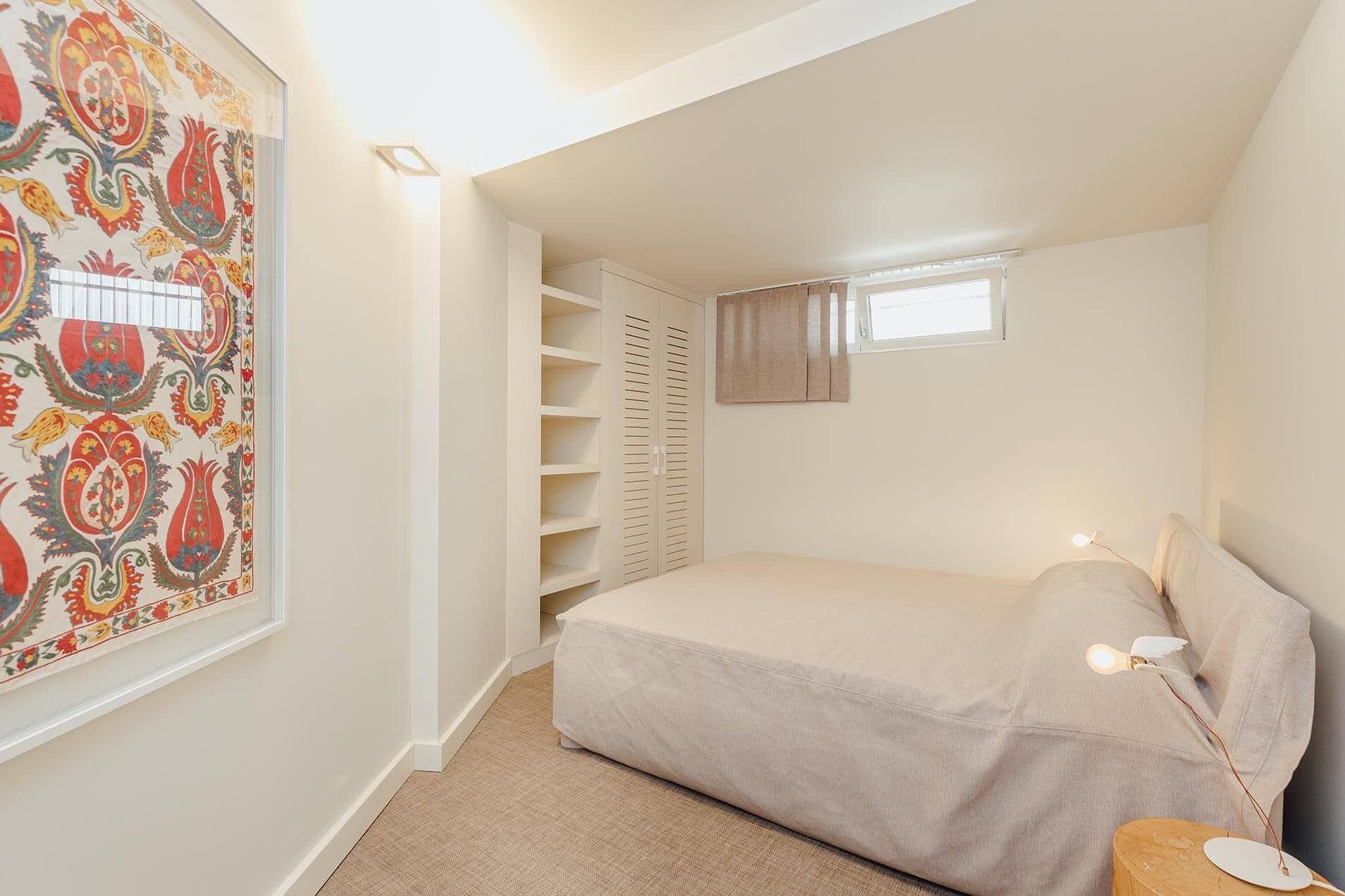 Cozy bedroom with a double bed and built-in wardrobe in a villa in Pržno, Montenegro. Modern bright interior.