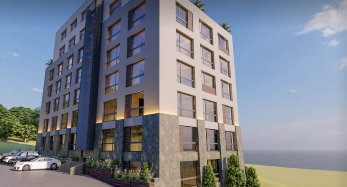 Karadağ, Bečići’de panoramik pencereli modern konut kompleksi: binanın cephesi ve otopark manzarası.