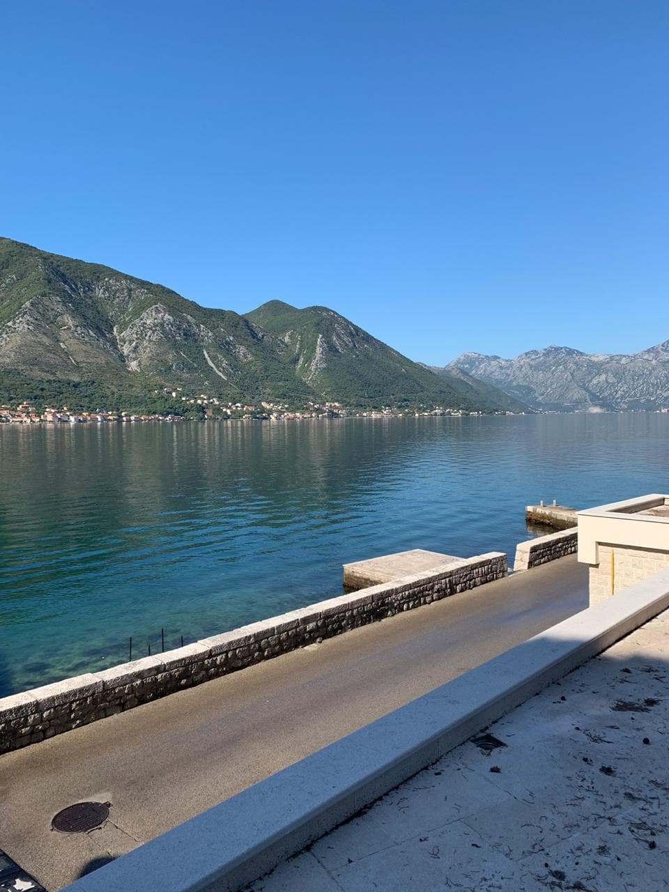 Panoramski pogled na Bokokotorski zaliv i planine sa terase vile u Dobroti, Crna Gora. Obala uz more.
