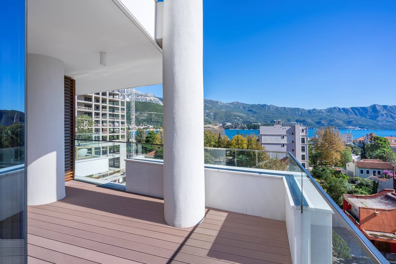 Budva, Karadağ’daki elit bir konut kompleksinde teras döşemeli, deniz ve dağ manzaralı geniş balkon.
