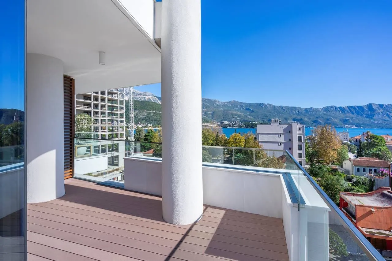 Geräumiger Balkon mit Terrassendielen und Panoramablick auf das Meer und die Berge in einer exklusiven Wohnanlage in Budva, Montenegro.