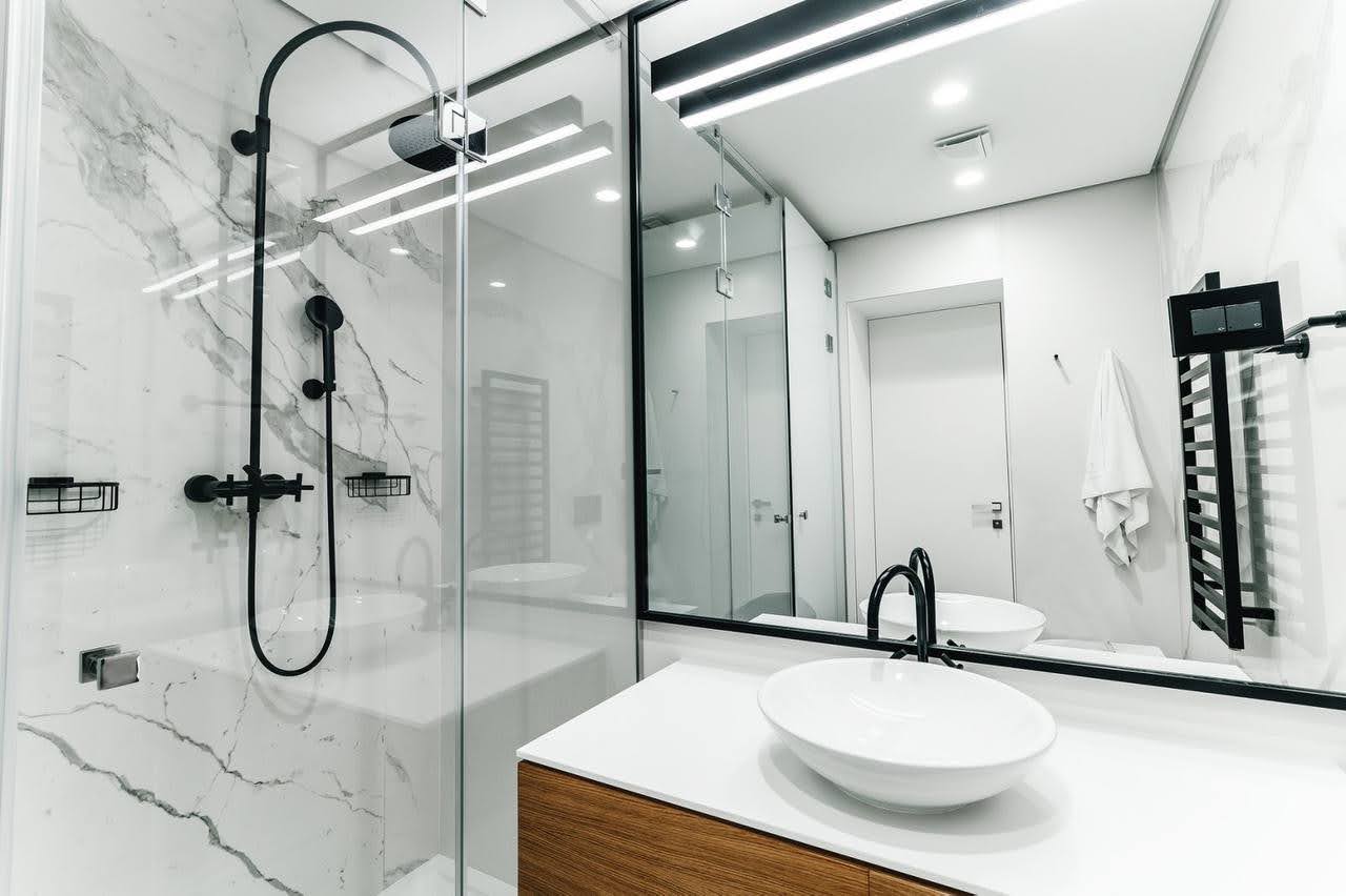 Mermer kaplamalı ve siyah armatürlü modern banyo, Budva, Karadağ.