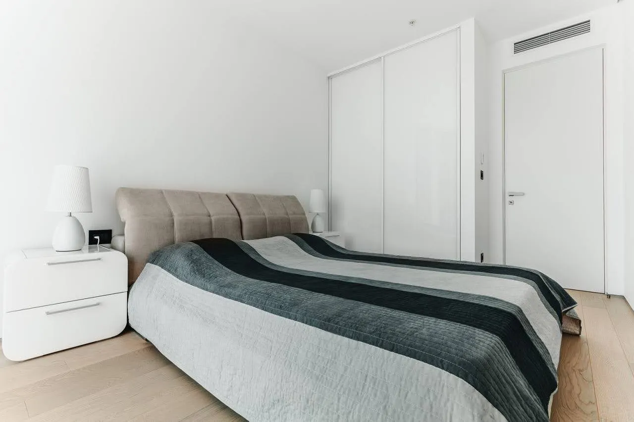 Modernes Schlafzimmer in einer Wohnung in Budva, Montenegro: Doppelbett, Einbauschrank und helles Interieur.