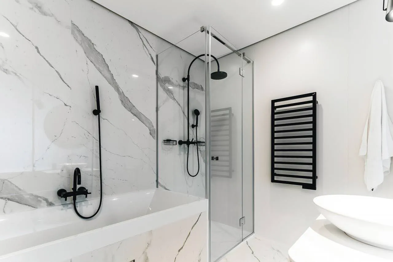 Modernes Badezimmer mit Duschkabine und Marmorverkleidung in einer Wohnung in Budva, Montenegro.