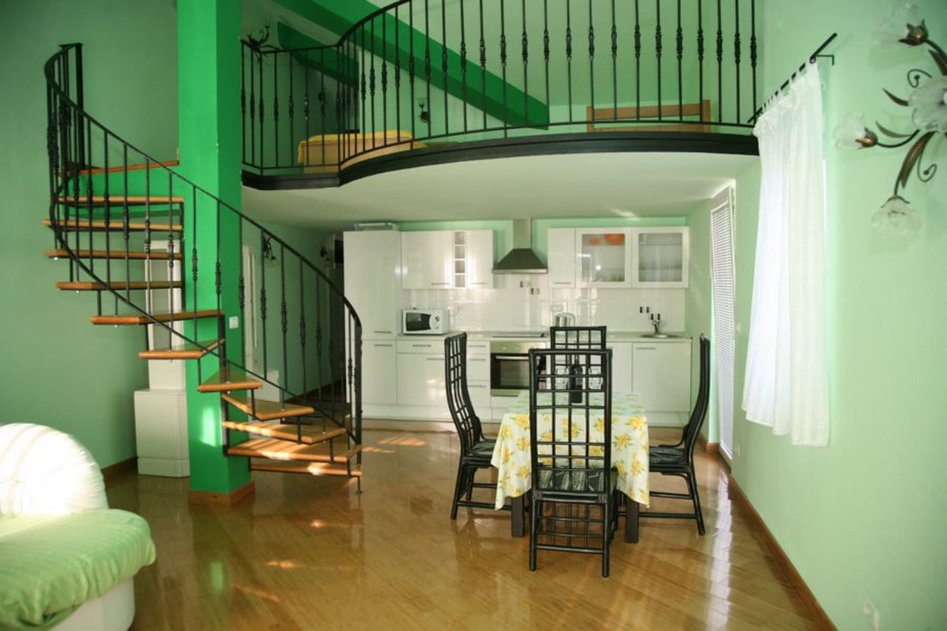 Wohnzimmer mit Wendeltreppe und Küche in einer Villa in Tivat, Montenegro: modernes Interieur mit Mezzanin und Essbereich.
