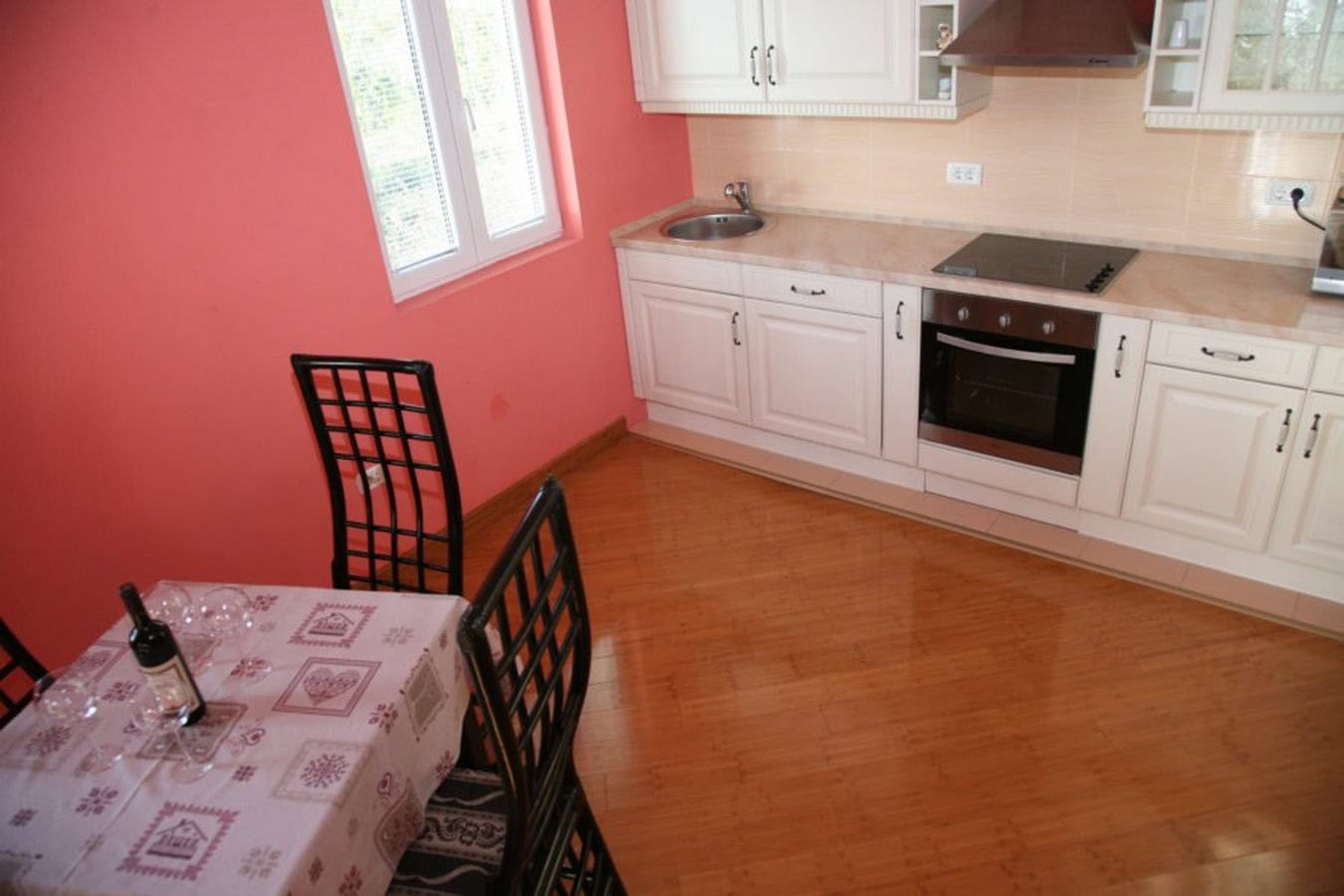 Helle Küche mit weißer Einbauküche und Essbereich in einer Villa in Tivat, Montenegro: moderne Geräte und gemütliches Interieur.