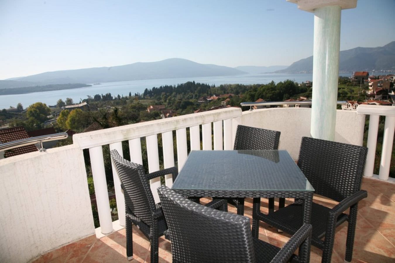 Terrasse mit Rattanmöbeln und Panoramablick auf das Meer und die Berge in einer Villa in Tivat, Montenegro.