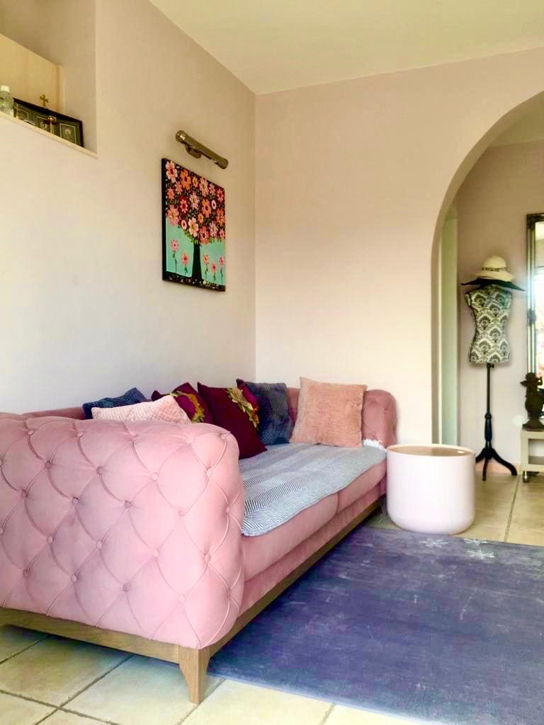 Dnevna soba sa roze sofom u enterijeru vile u Šušnju, Crna Gora: prijatna zona za odmor sa lučnim prolazom.