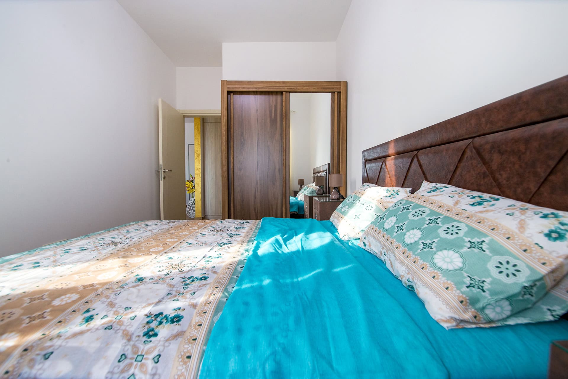 Gemütliches Schlafzimmer mit Doppelbett und Spiegelschrank in einer Wohnung in Bečići, Montenegro.