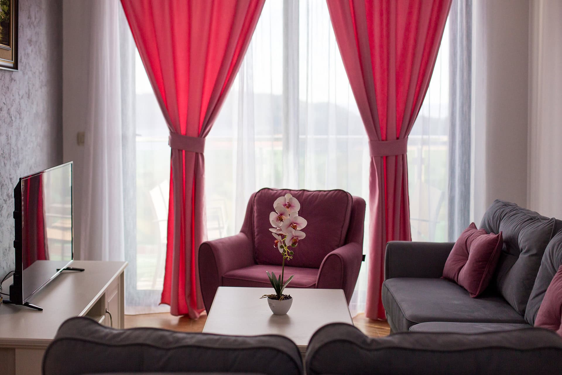 Gemütliches Wohnzimmer mit Polstermöbeln und Panoramafenster in einer Wohnung in Bečići, Montenegro. Modernes Interieur mit TV.