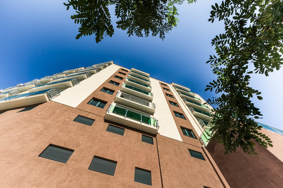 Moderner Wohnkomplex in Bečići, Montenegro: Ansicht der Gebäudefassade von unten mit Balkonen und Panoramafenstern.