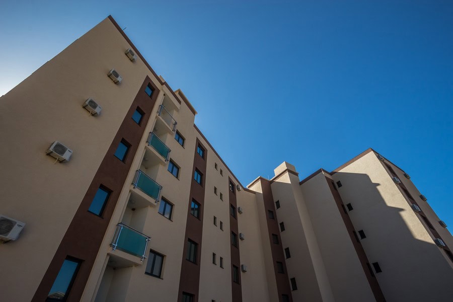 Moderner Wohnkomplex mit Balkonen in Bečići, Montenegro: Blick auf die Fassade des Gebäudes mit Klimaanlagen und Panoramahimmel.