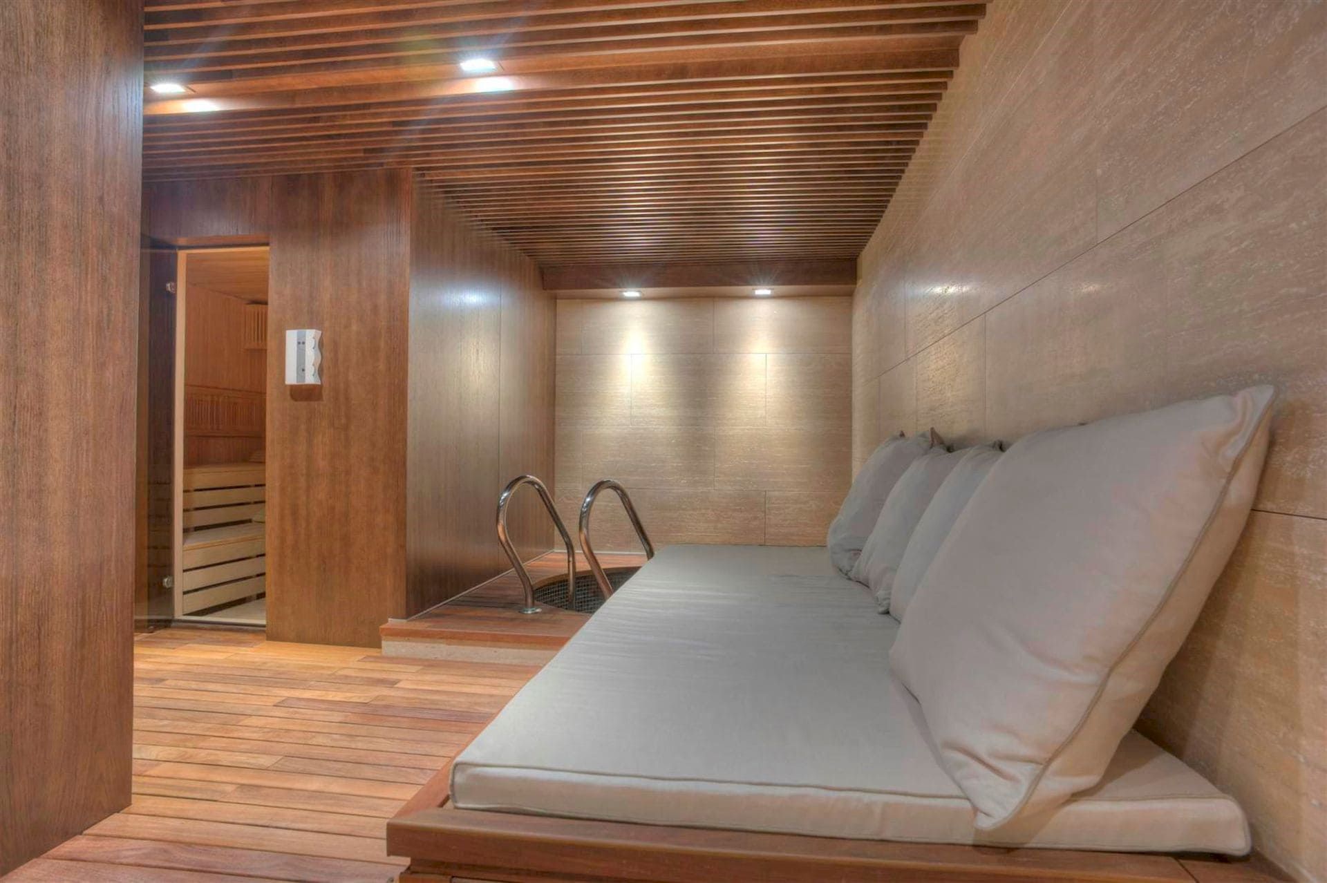Espace spa avec sauna et bassin dans une villa de luxe à Krašići, Monténégro : finition moderne en bois et coin détente.