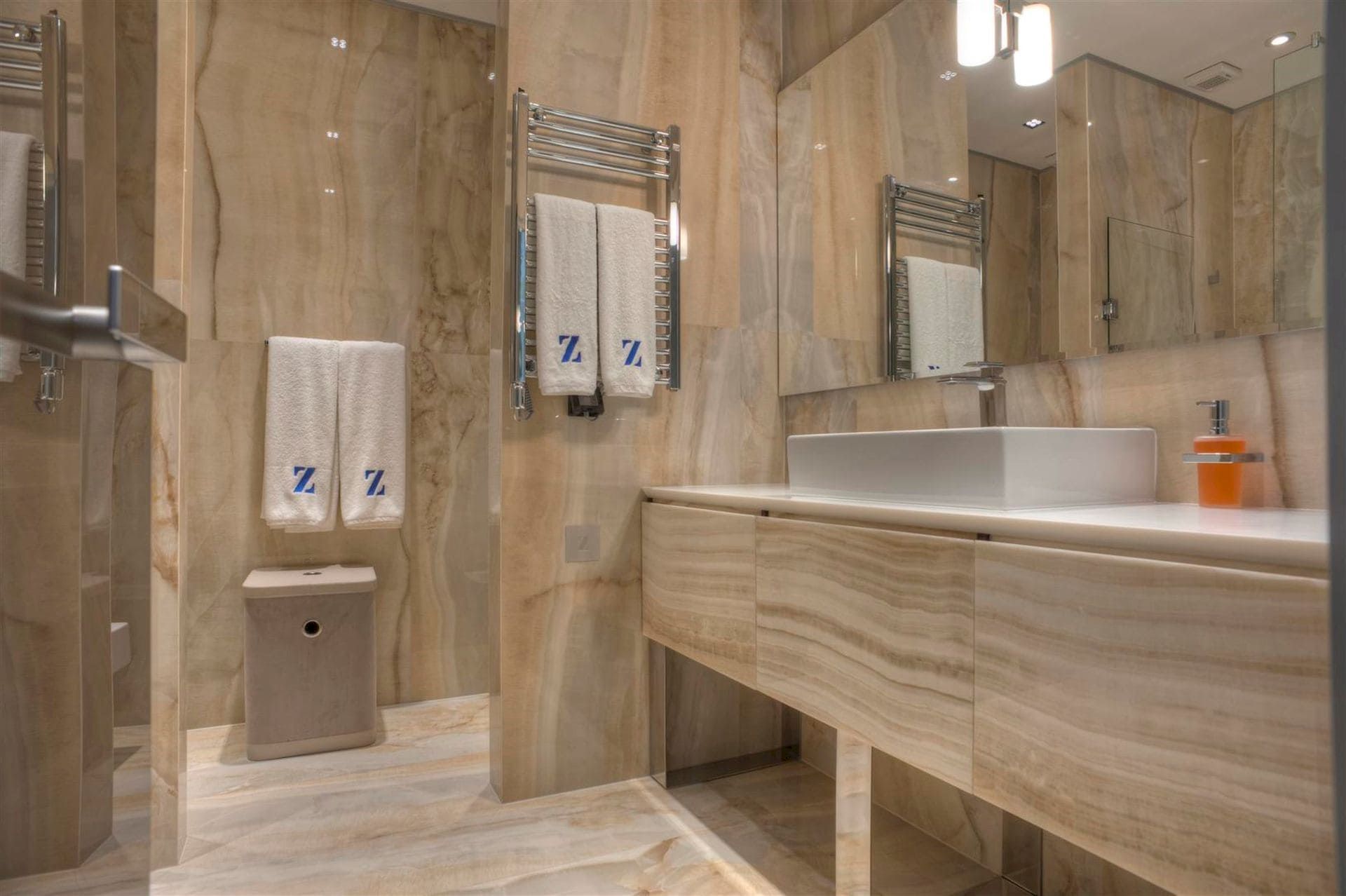 Salle de bains moderne avec finition en marbre beige dans une villa à Krašići, Monténégro : lavabo et décoration élégante.