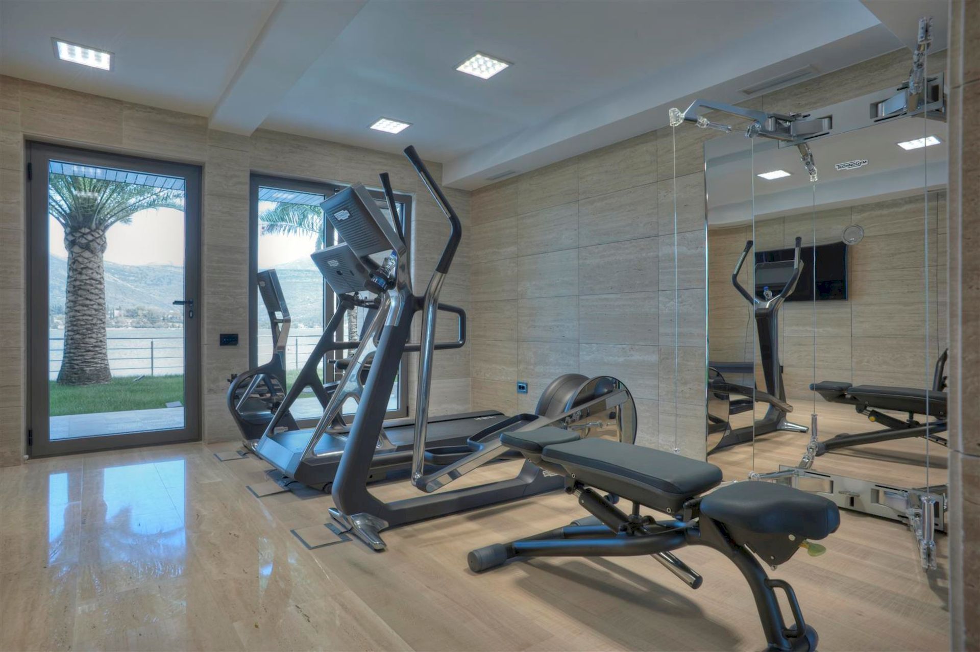 Salle de sport moderne dans une villa à Krašići, Monténégro, avec vue panoramique sur la mer et équipement professionnel.