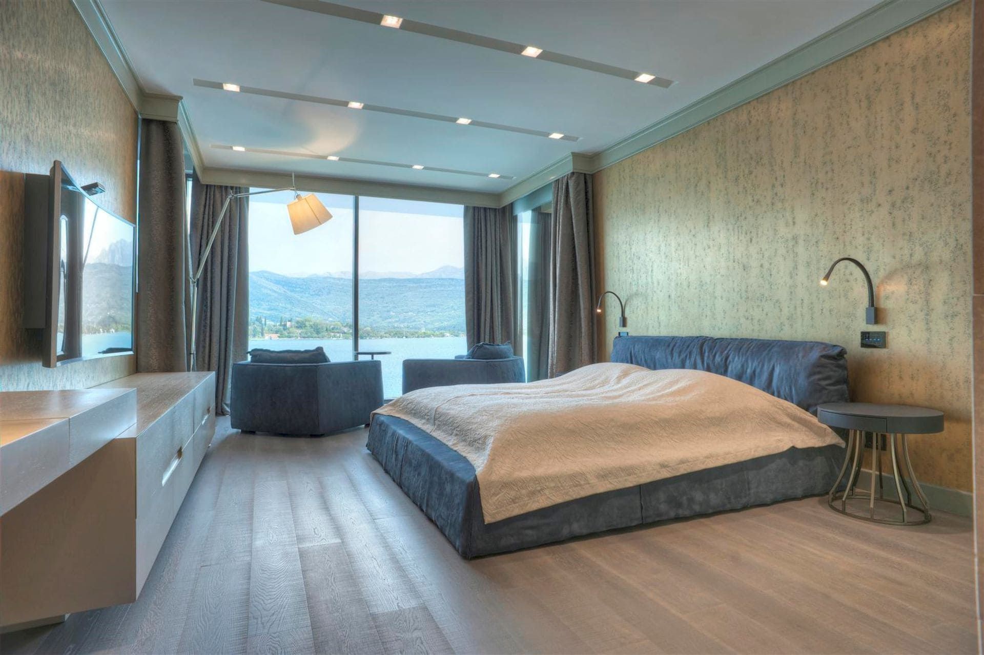 Chambre moderne avec vue sur la mer dans une villa à Krašići, Monténégro : lit double, baies vitrées panoramiques et décoration.
