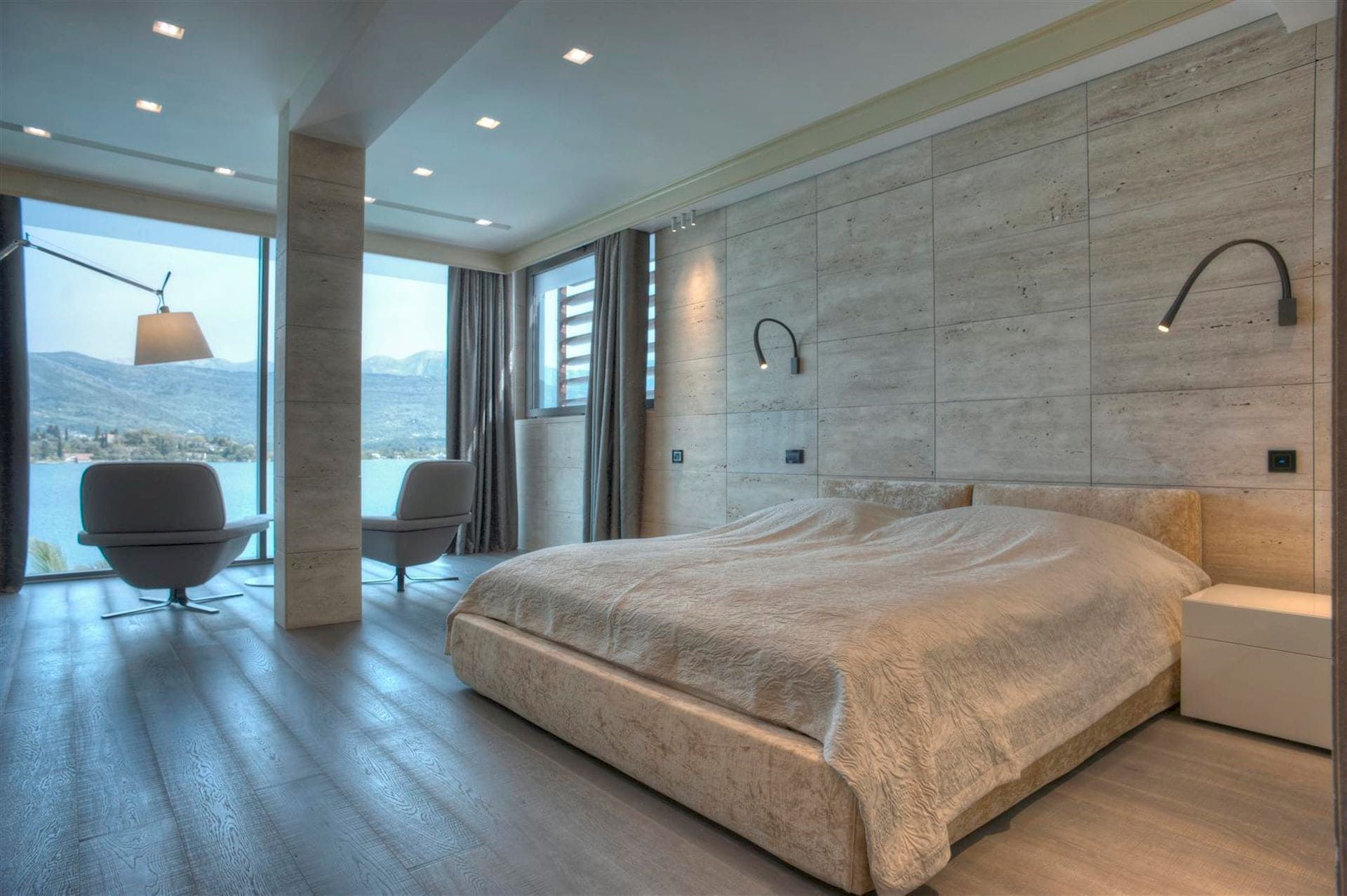 Chambre moderne avec vue panoramique sur la mer et les montagnes dans une villa, Krašići, Monténégro : finition en pierre et lit double.